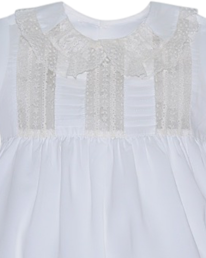 White dress with lace detailing on a plain background