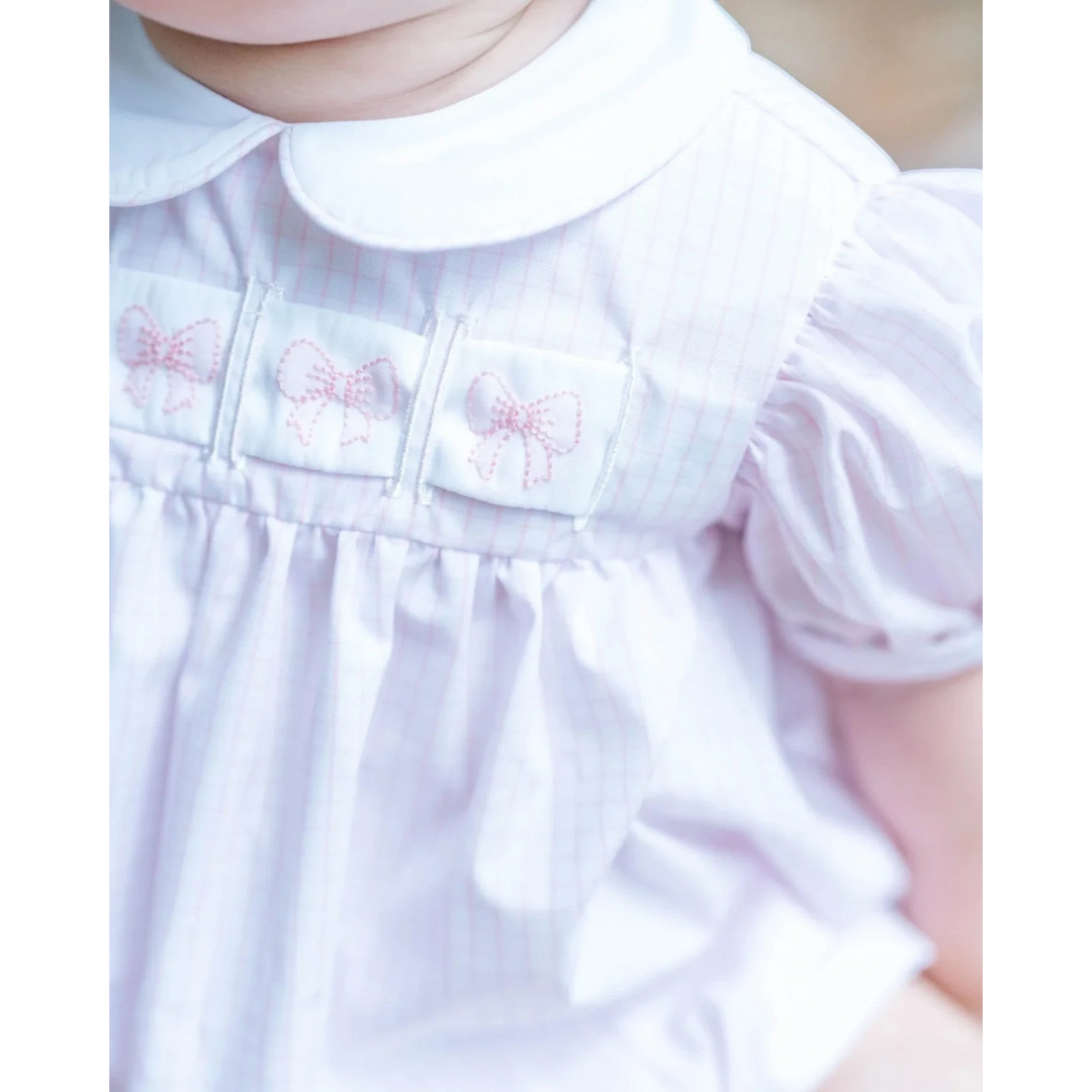 Close-up of a light purple dress with butterfly patterns on a blurred background