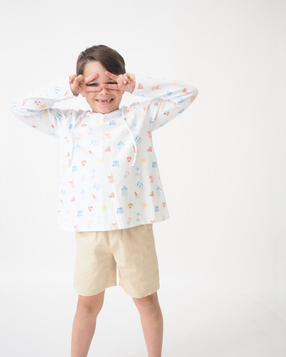 Child wearing a white raincoat with colorful patterns on a white background