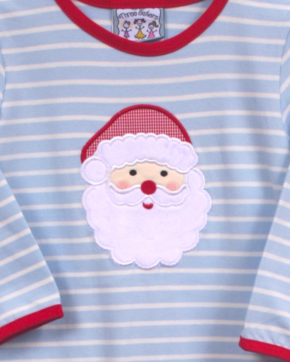 A close-up of a baby long-sleeve shirt with light blue and white horizontal stripes, featuring a red crew neck and cuffs, and a white embroidered Santa Claus face patch on the chest, that store