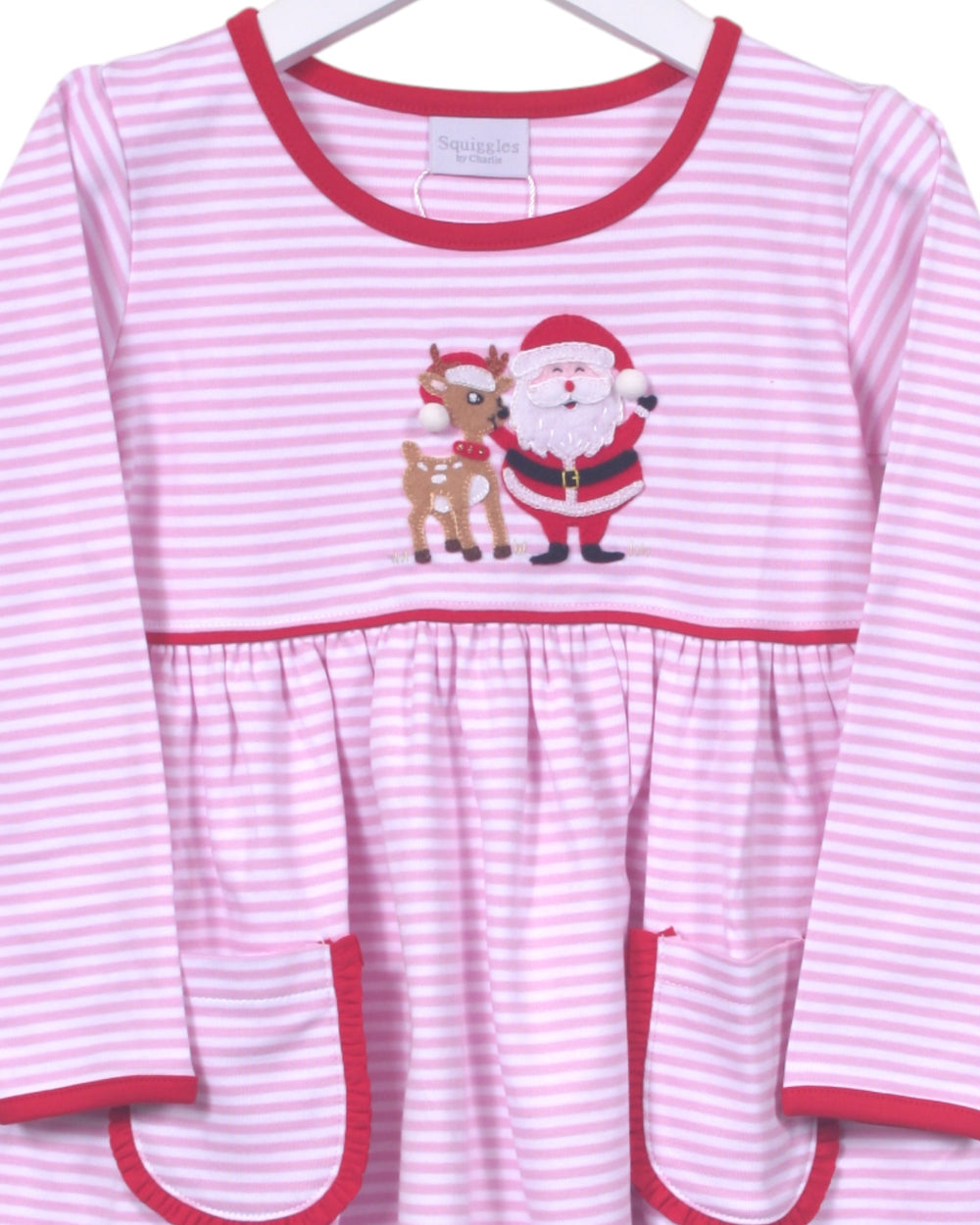 Pink and white striped dress with Santa and reindeer design on a hanger
