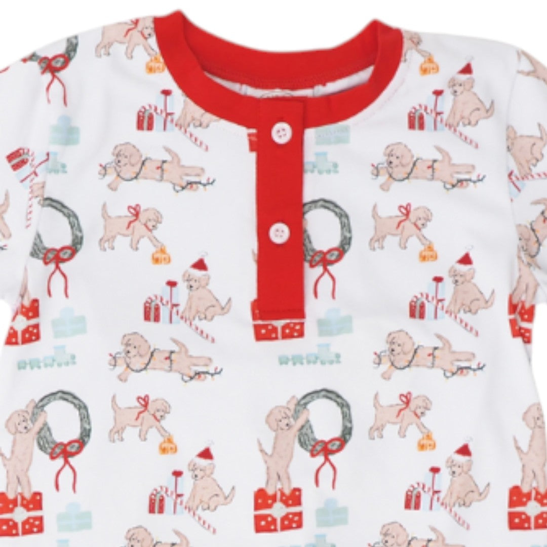 A close-up of a baby long-sleeve top featuring a white base with a festive Christmas print of golden retriever dogs, wreaths, candy canes, and presents, accented by a solid red collar and button placket, that store