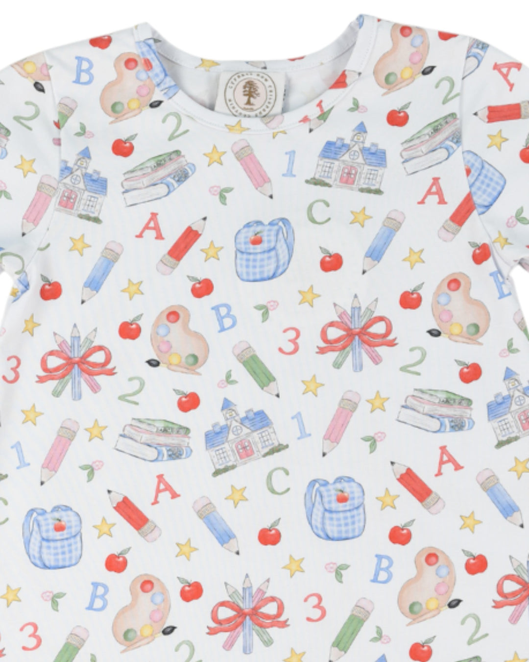Children's shirt with educational pattern including letters, numbers, and school-related items on a white background.