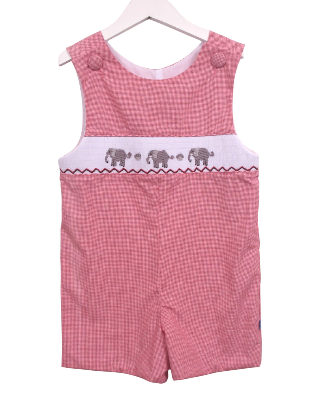 A pink sleeveless baby romper with a white chest band featuring embroidered gray elephants, shown hanging on a white wooden hanger against a white background, that store