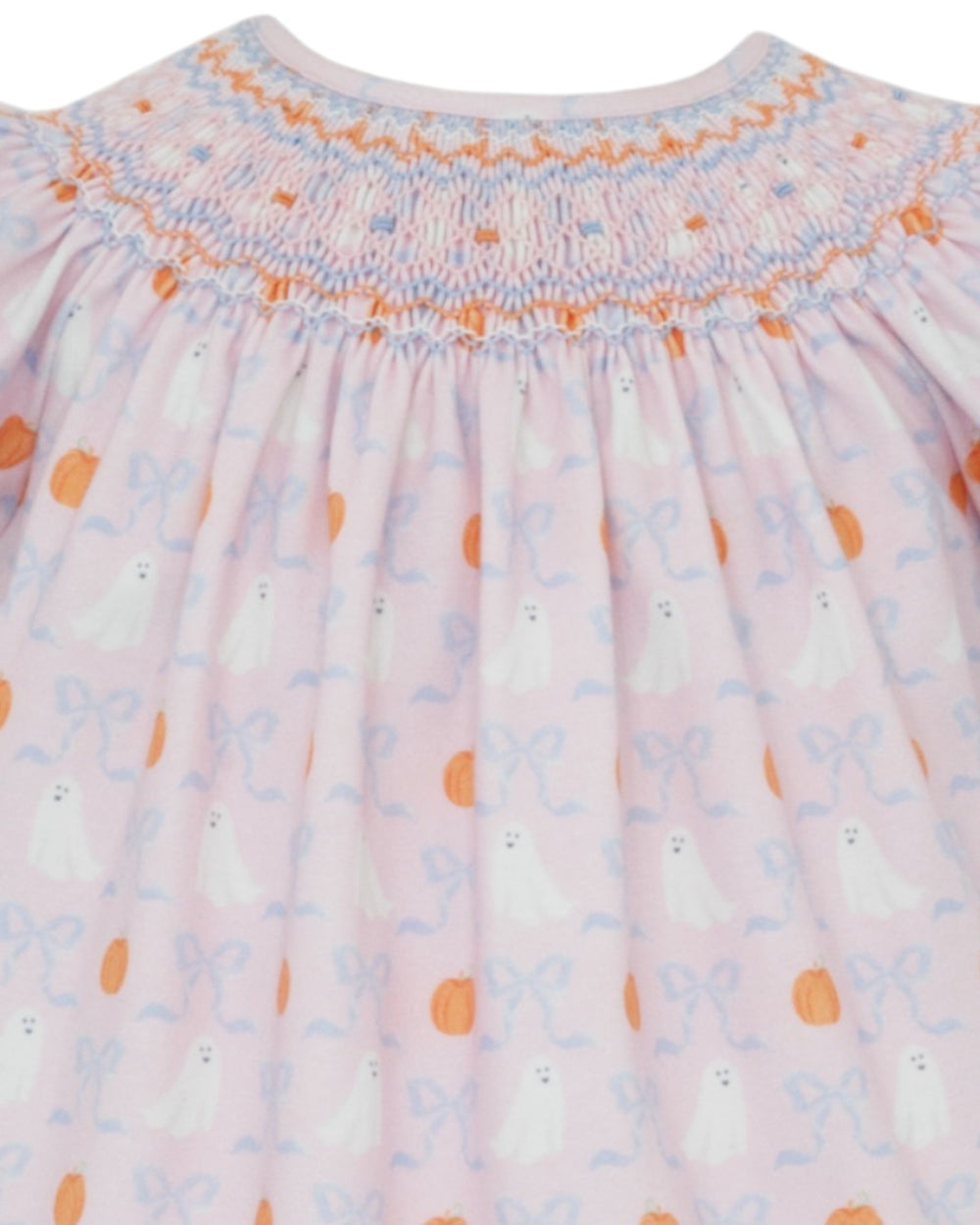 Close-up of a baby dress with smocked neckline and floral pattern