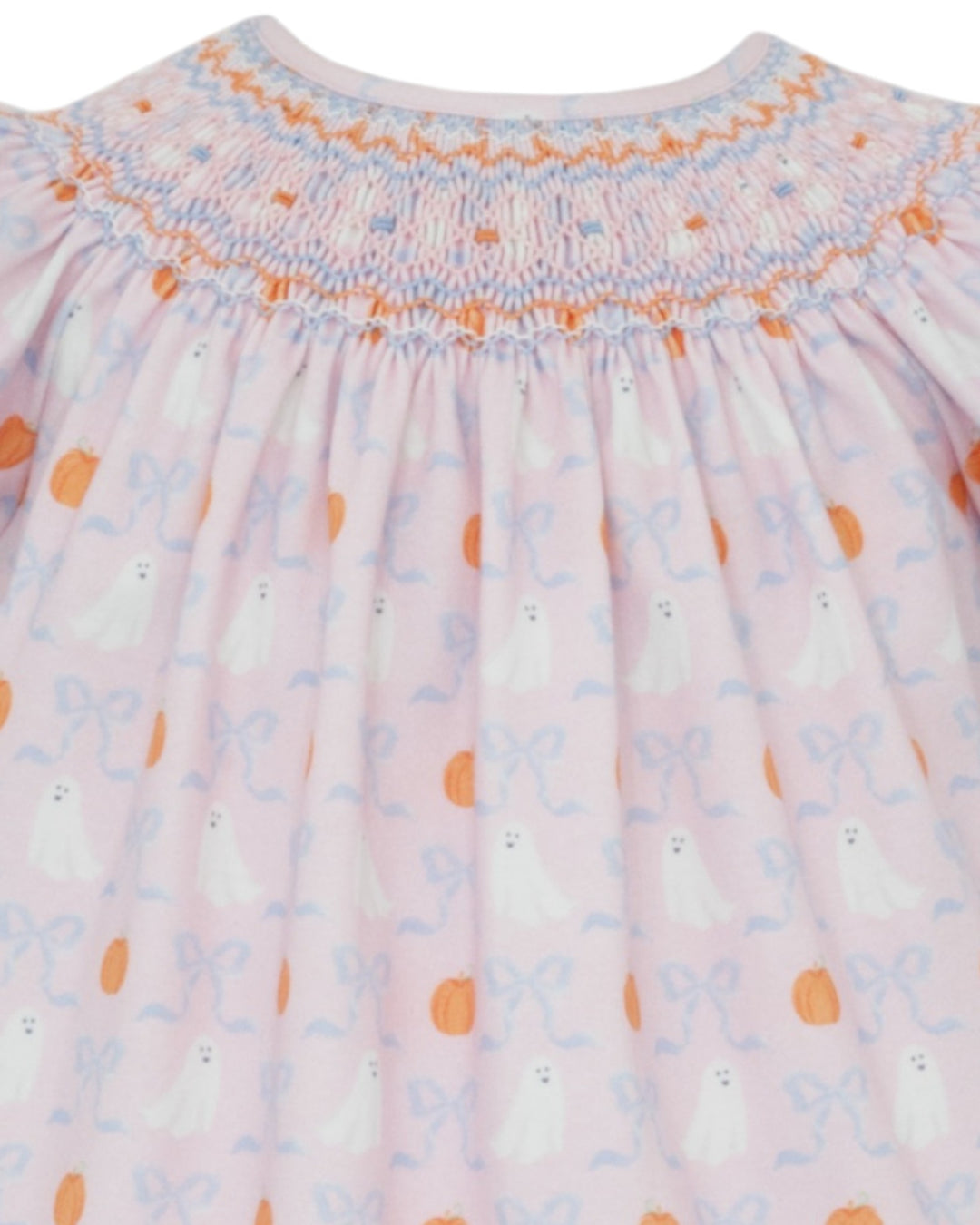Close-up of a baby dress with smocked neckline and floral pattern