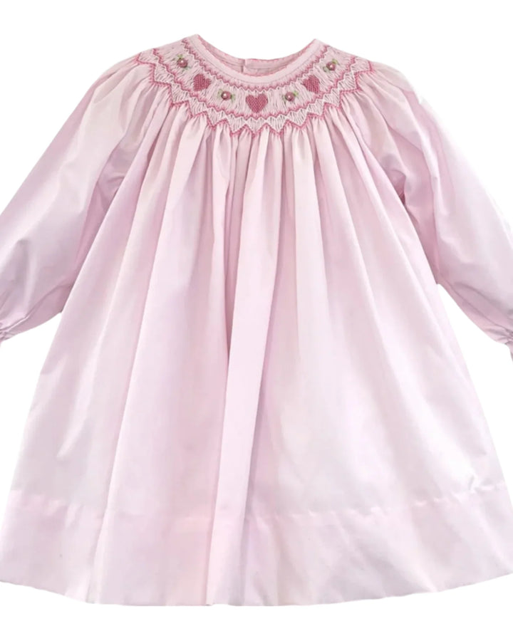 Pink dress with smocked neckline on a white background
