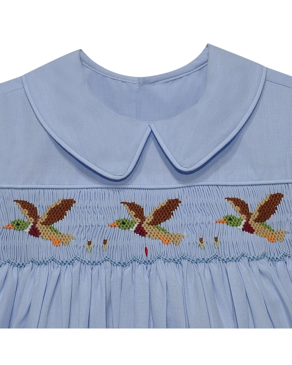 Light blue dress with embroidered birds on a white background