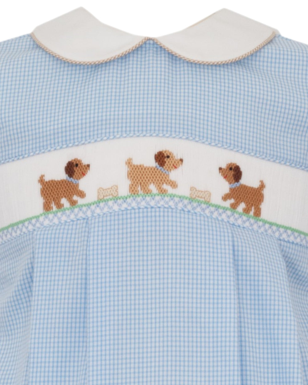 Close-up of a baby dress with a light blue and white gingham pattern, a white Peter Pan collar, and a smocked band featuring embroidered brown dogs and white bones, that store
