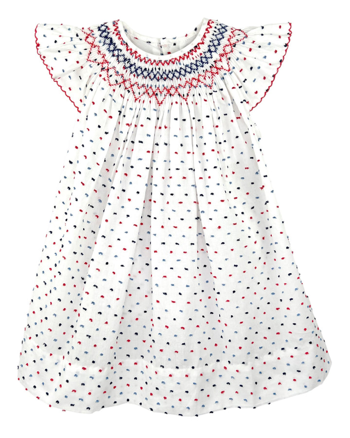 White dress with red and blue smocked neckline on a white background