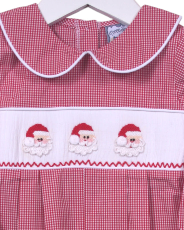Red gingham dress with embroidered Santa faces on a hanger