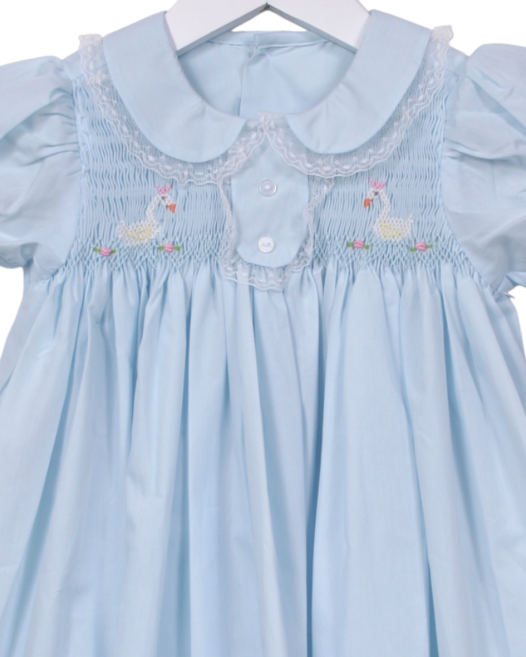 Light blue dress with smocked collar and duck embroidery on a hanger.