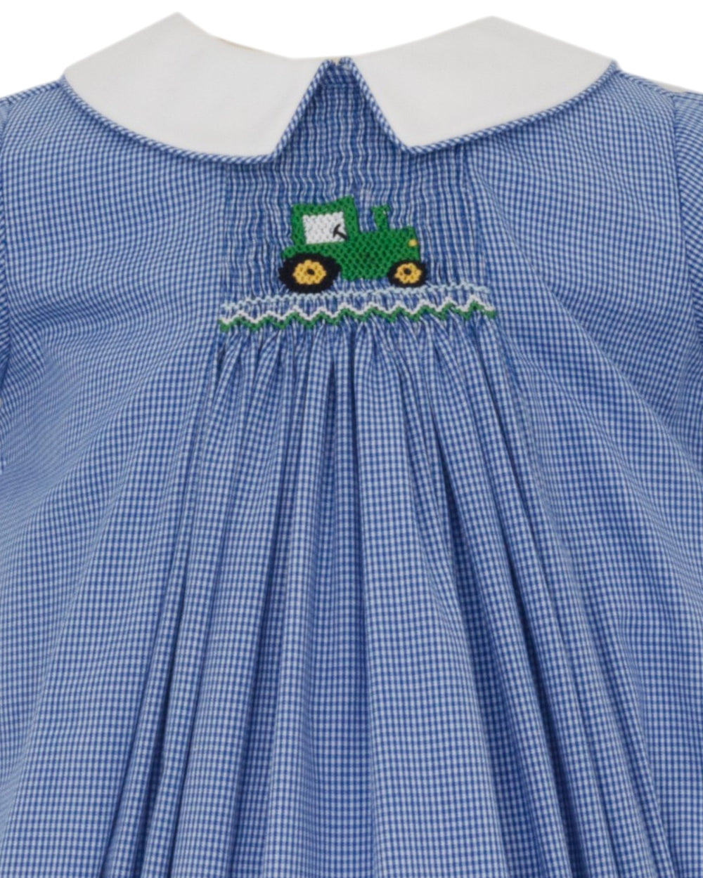Close-up of a blue and white gingham dress with a white Peter Pan collar and a green tractor embroidery at the center of the chest, that store