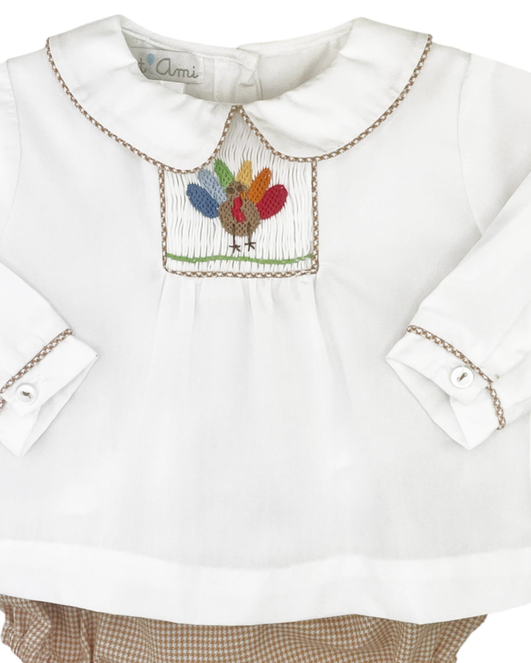 White blouse with embroidered colorful turkey design on a white background
