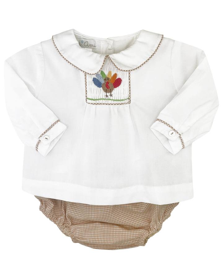 White baby outfit with embroidered design on a white background