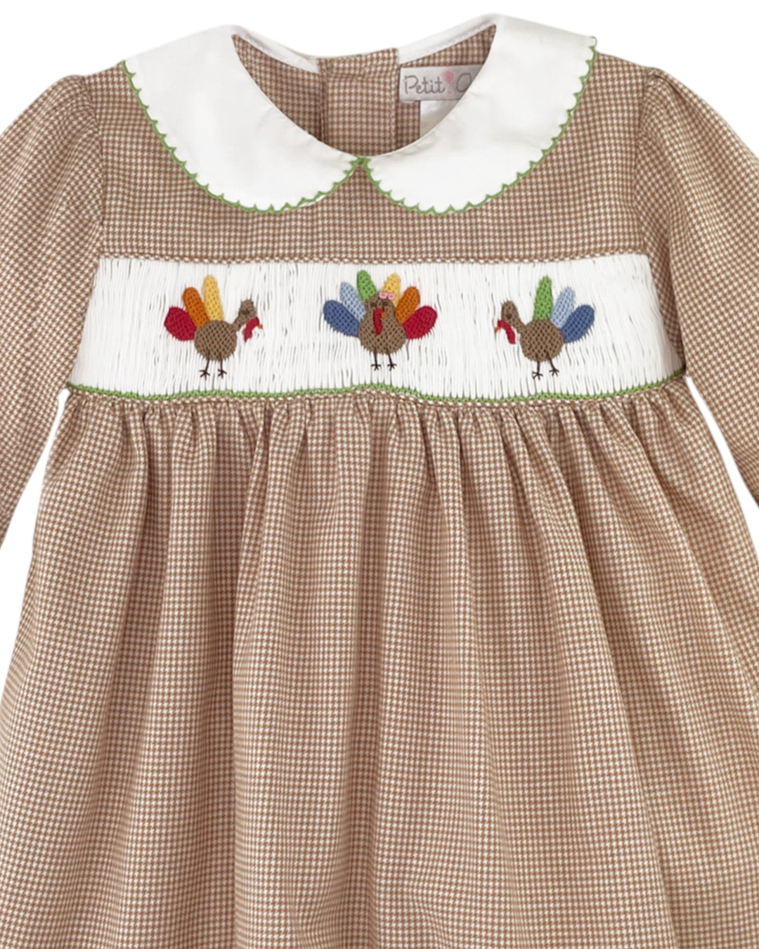Children's dress with checkered pattern and embroidered turkeys on a white background