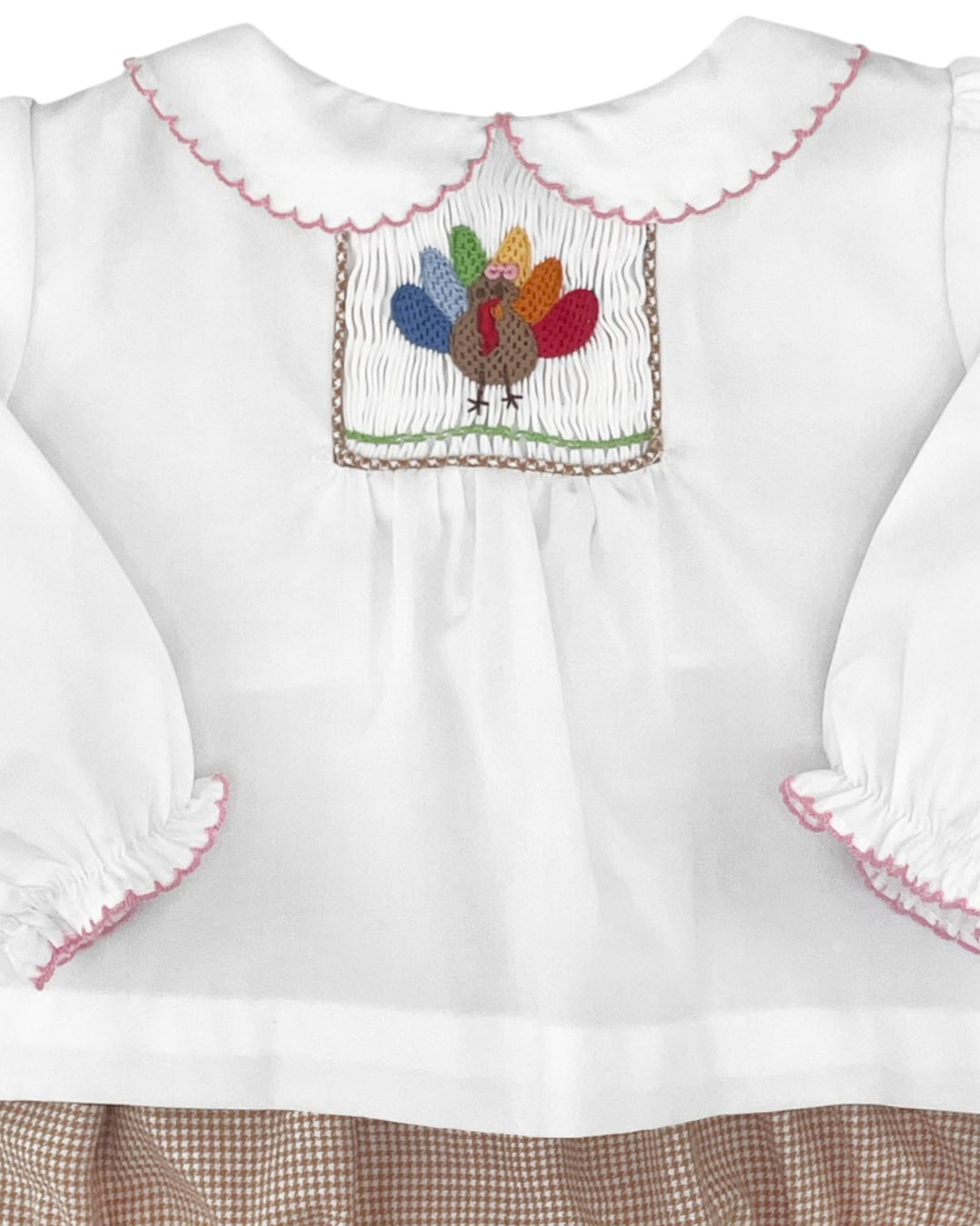 White blouse with colorful embroidered turkey design on a white background