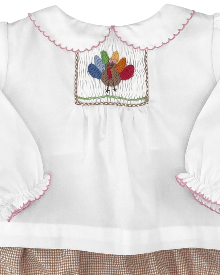 White blouse with colorful embroidered turkey design on a white background