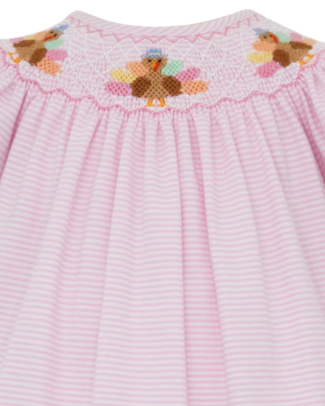 Pink dress with embroidered teddy bear design on a white background