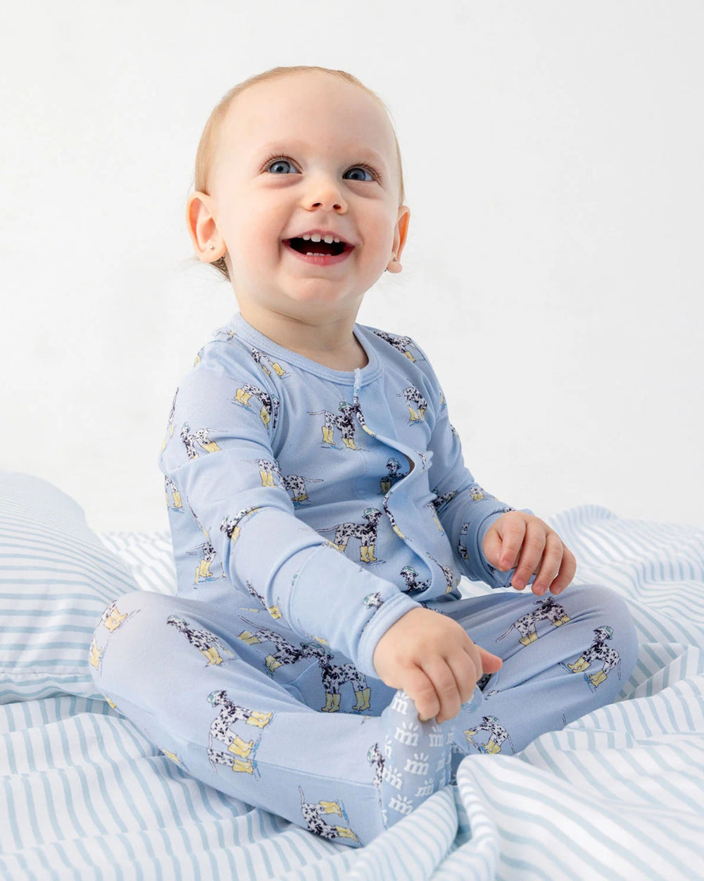 Baby wearing a blue outfit with animal prints on a white background