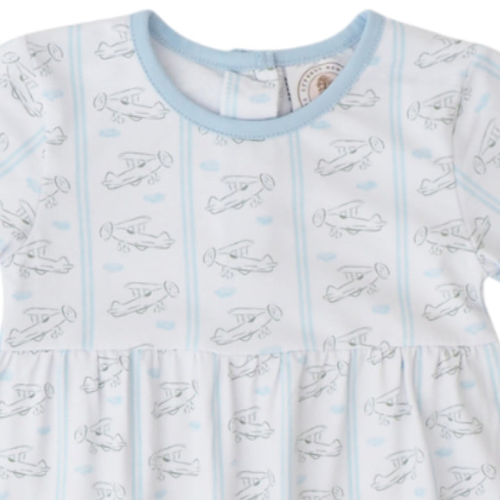 A close-up of a baby dress featuring a white base with light blue vertical stripes, a light blue crew neck, and an allover print of simple black line drawings of vintage airplanes, that store