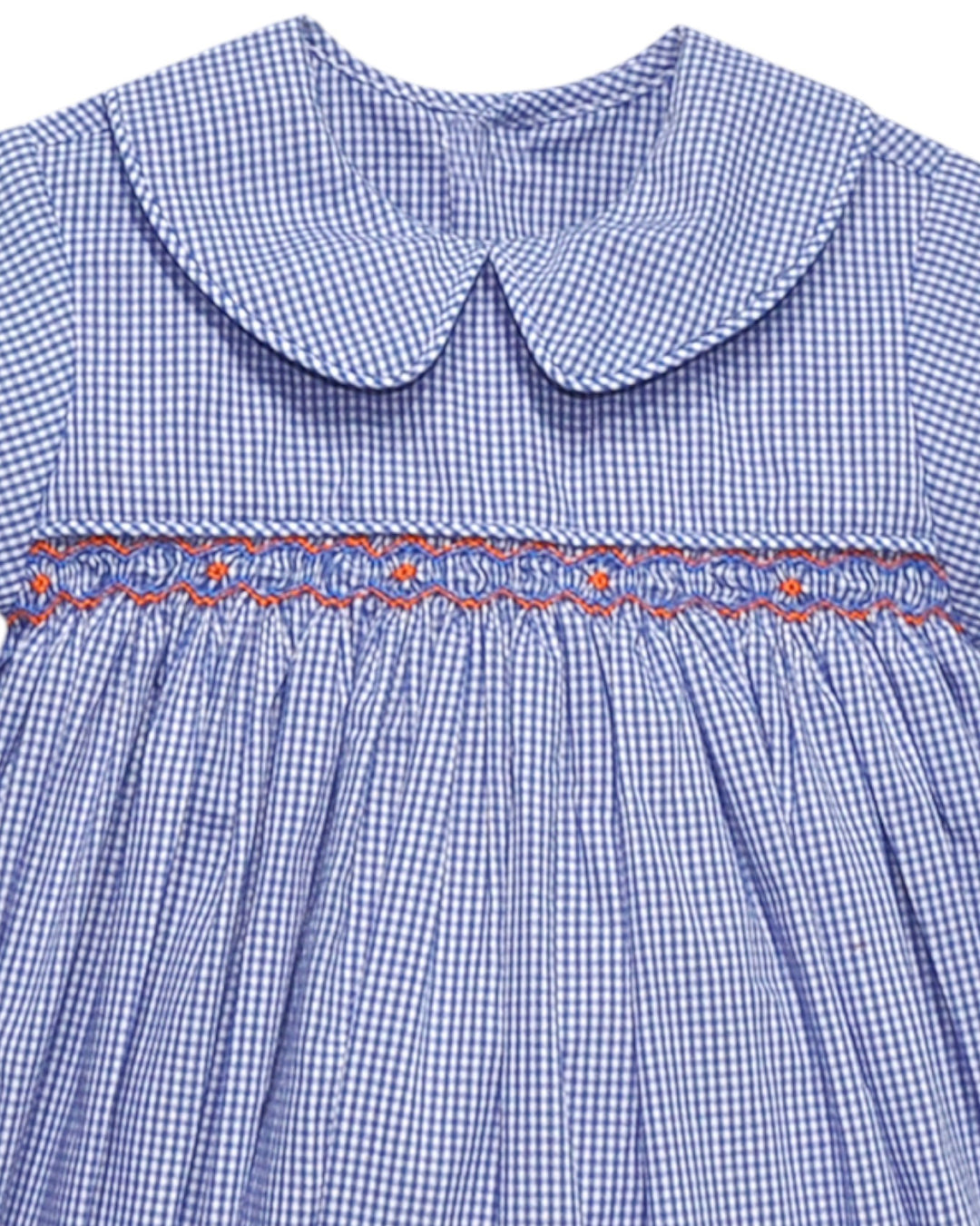 Close-up of a blue checkered dress with a smocked waistline and embroidered details.