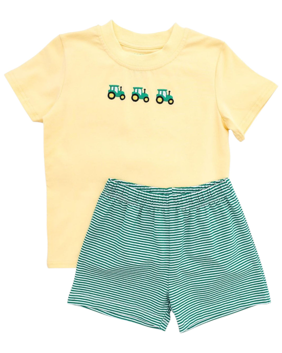 Yellow t-shirt with green tractors and green striped shorts on a white background