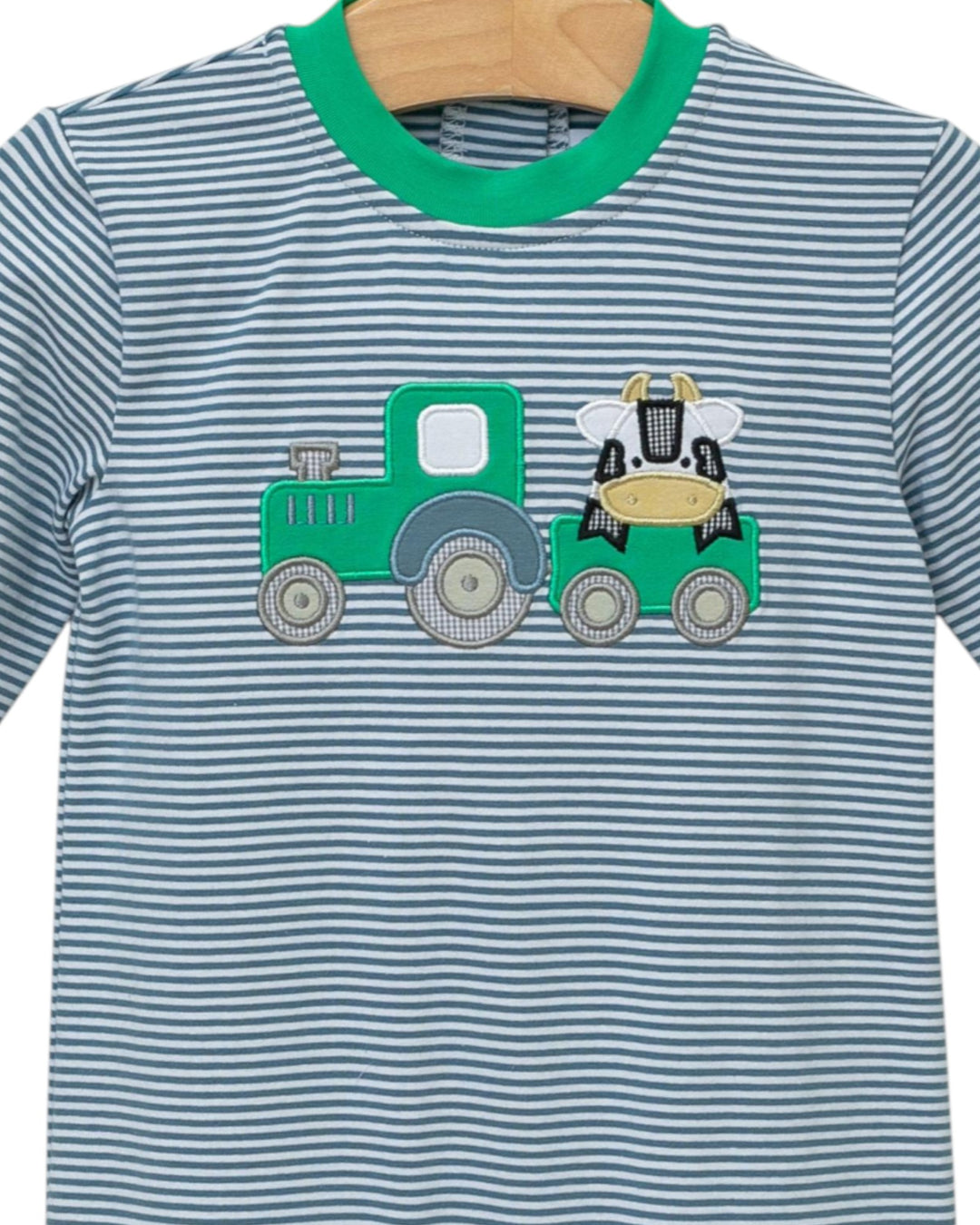Children's t-shirt with a green tractor and cow design on a striped background