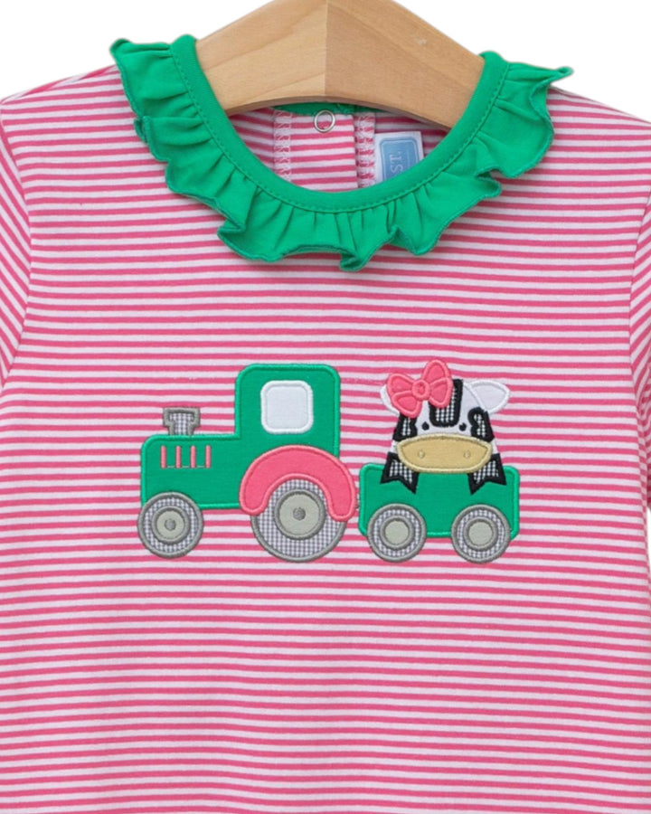 Pink and white striped shirt with green ruffled collar and tractor applique on a hanger.