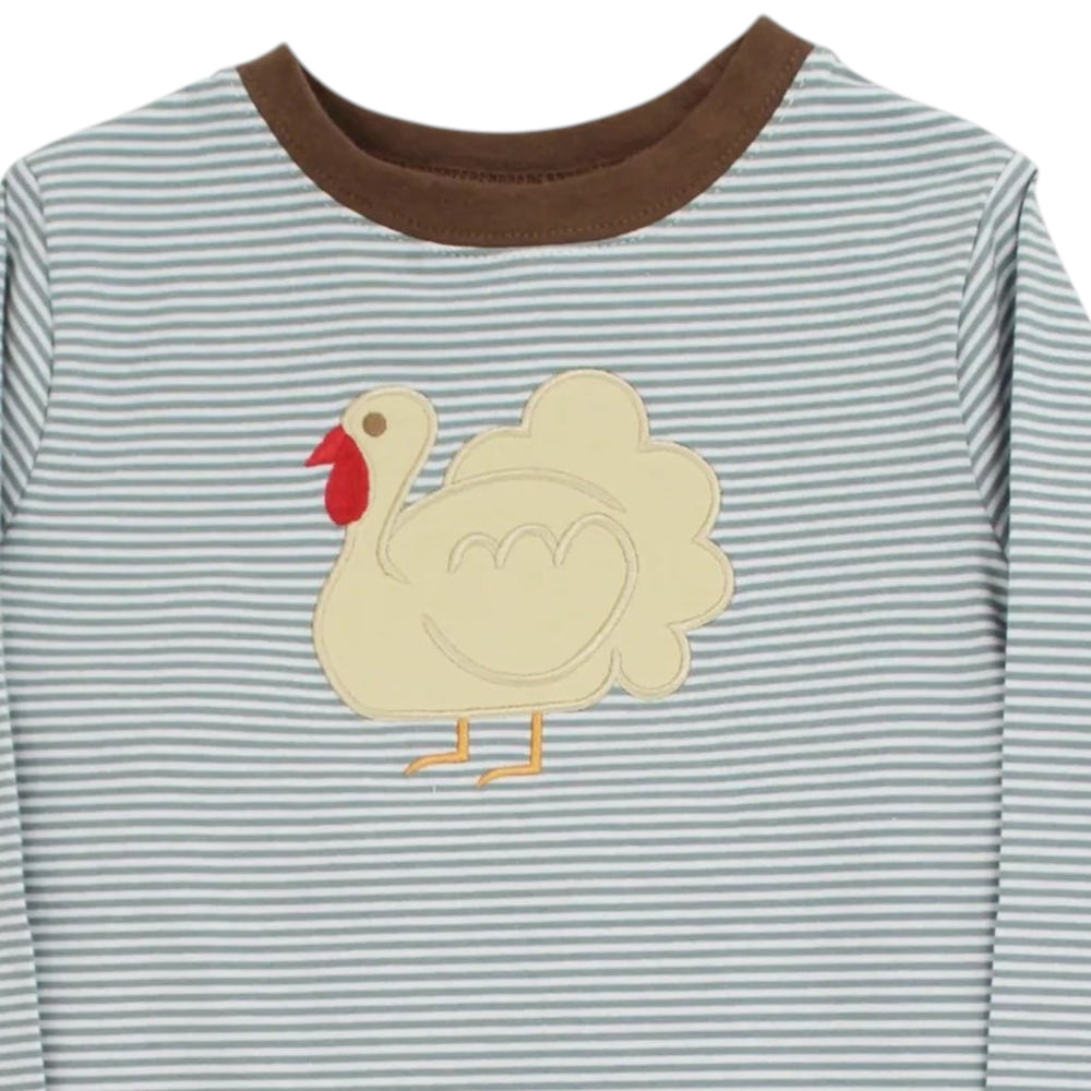 A close-up of a long-sleeve baby shirt with thin blue and white horizontal stripes, a brown ribbed crew neck, and a cream-colored applique turkey on the chest, that store