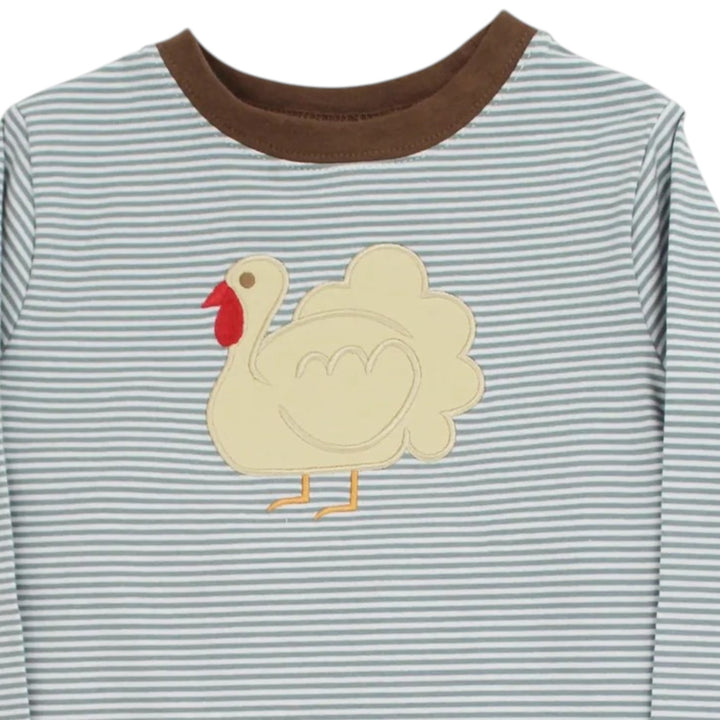 A close-up of a long-sleeve baby shirt with thin blue and white horizontal stripes, a brown ribbed crew neck, and a cream-colored applique turkey on the chest, that store