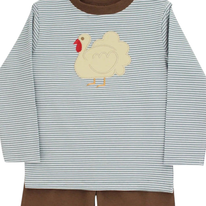 A baby long-sleeve shirt with thin blue and white horizontal stripes, featuring a cream-colored applique turkey on the chest with a red wattle and yellow beak and legs. The shirt has a solid brown crew neck and is shown paired with brown pants against a white background, that store