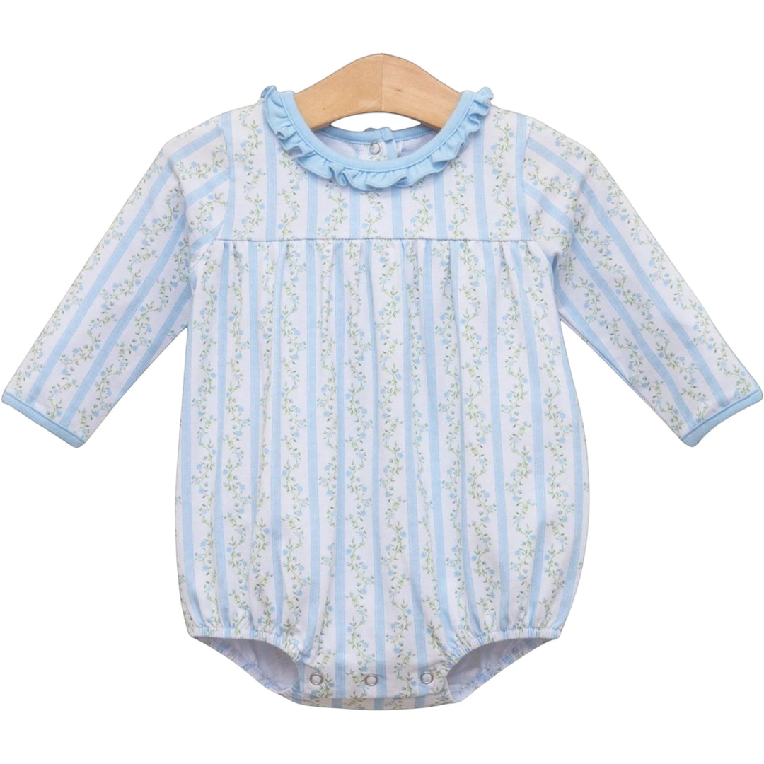 A baby long-sleeve romper with vertical light blue and white stripes, a delicate green floral pattern, and a light blue ruffled collar, hanging on a wooden hanger against a white background, that store