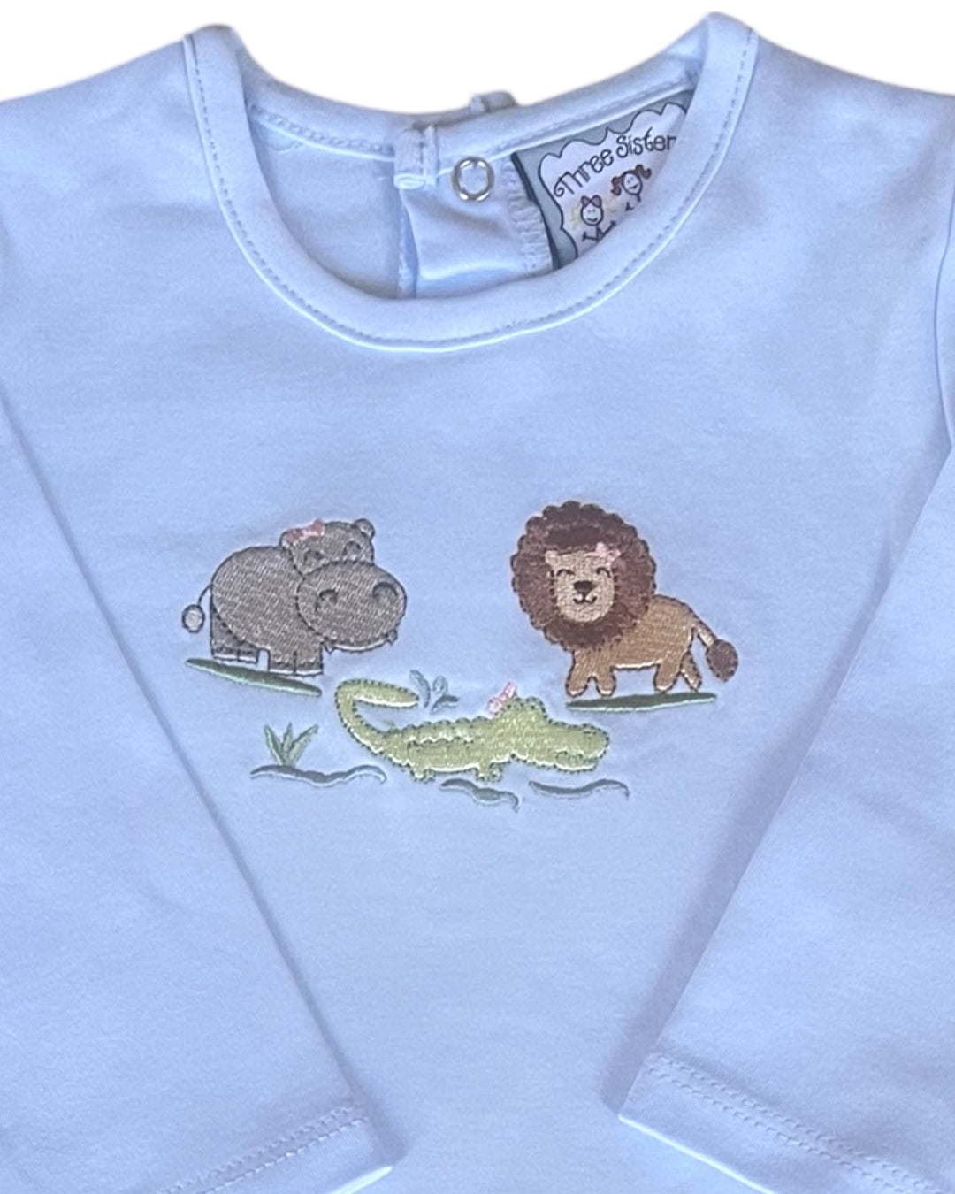 Children's shirt with embroidered lion, hippo, and crocodile design on a light blue background.