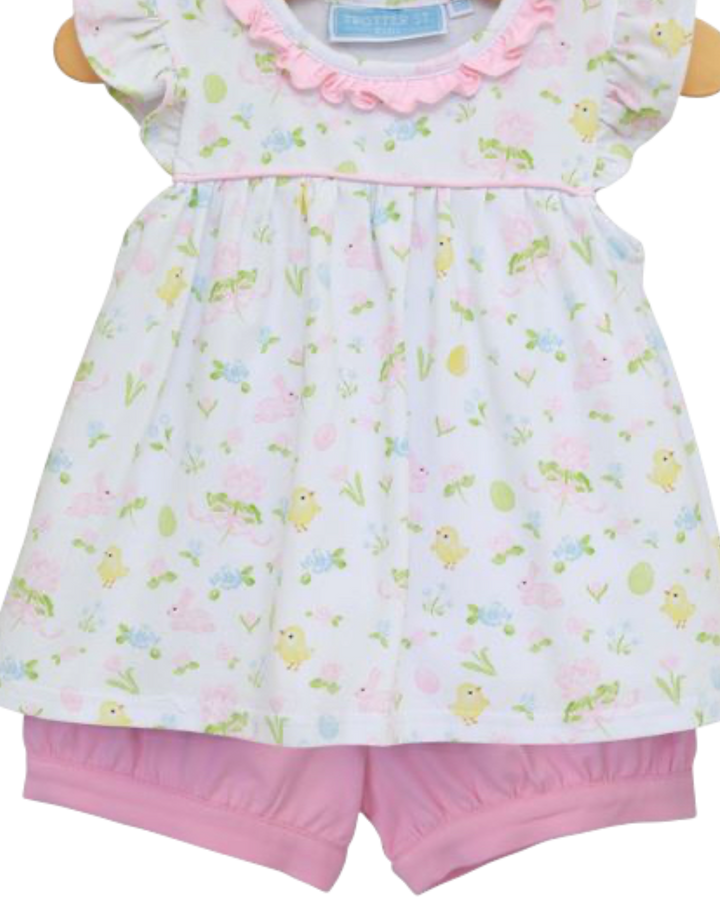 Children's outfit with floral top and pink shorts on a wooden hanger.