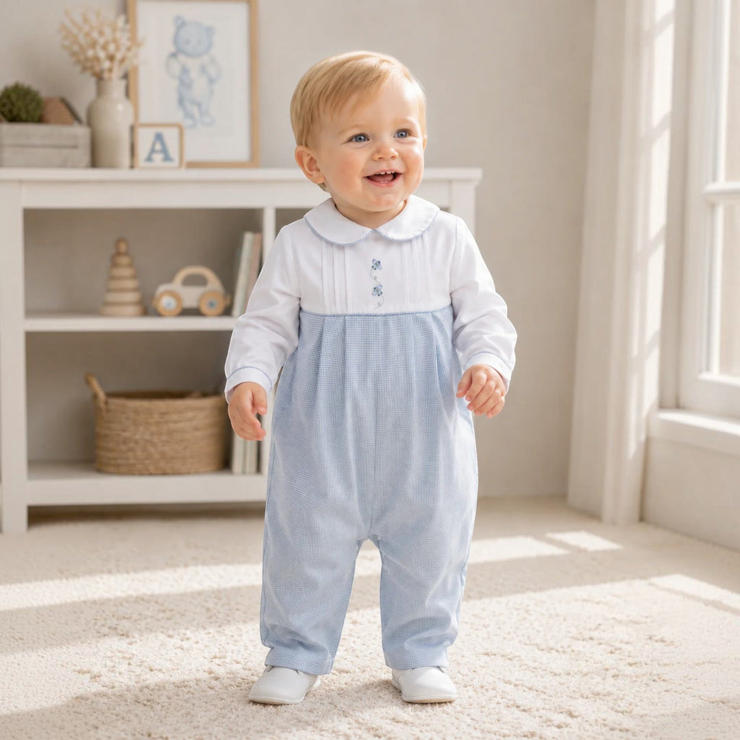 That Store baby boy wearing a blue mini check longall with airplane embroidery and a white Peter Pan collar