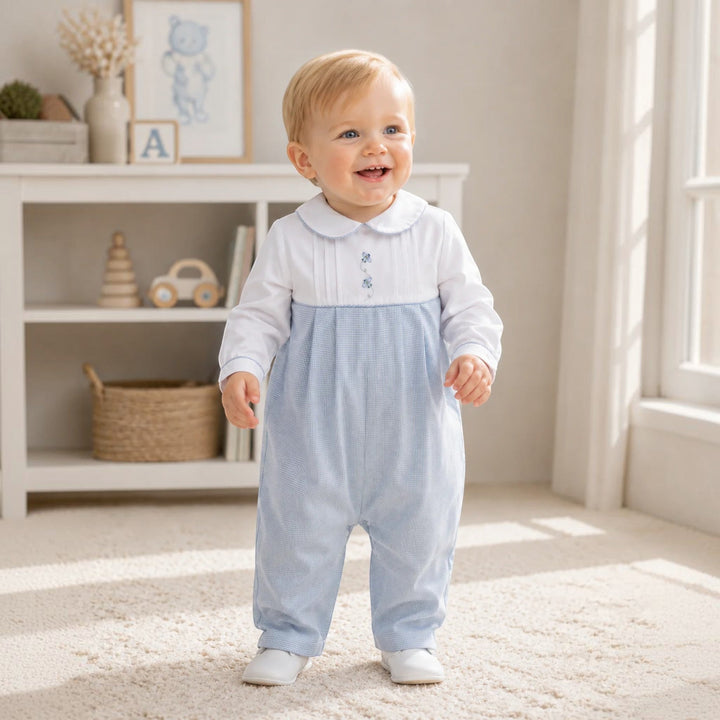 That Store baby boy wearing a blue mini check longall with airplane embroidery and a white Peter Pan collar