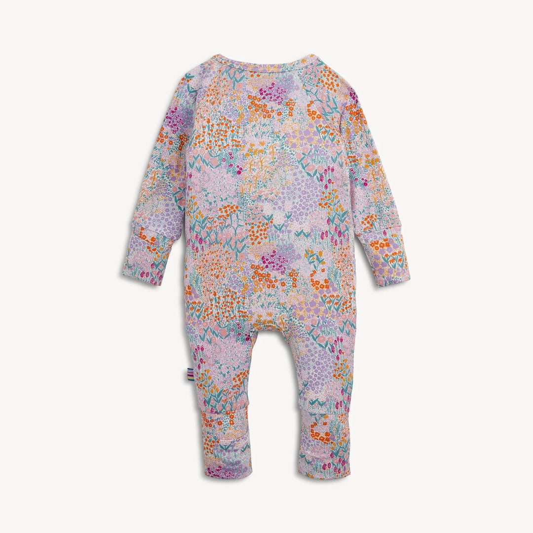 Back view of That Store Arabella modal convertible coverall featuring a colorful floral print on a light purple base.