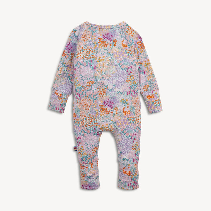 Back view of That Store Arabella modal convertible coverall featuring a colorful floral print on a light purple base.