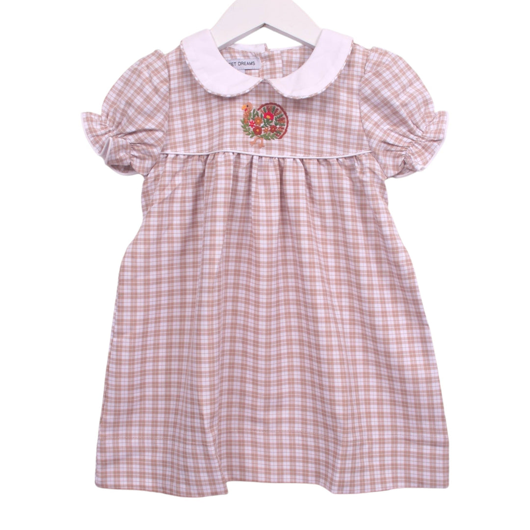 That Store beige and white plaid toddler dress with a white Peter Pan collar, puff sleeves, and turkey embroidery.