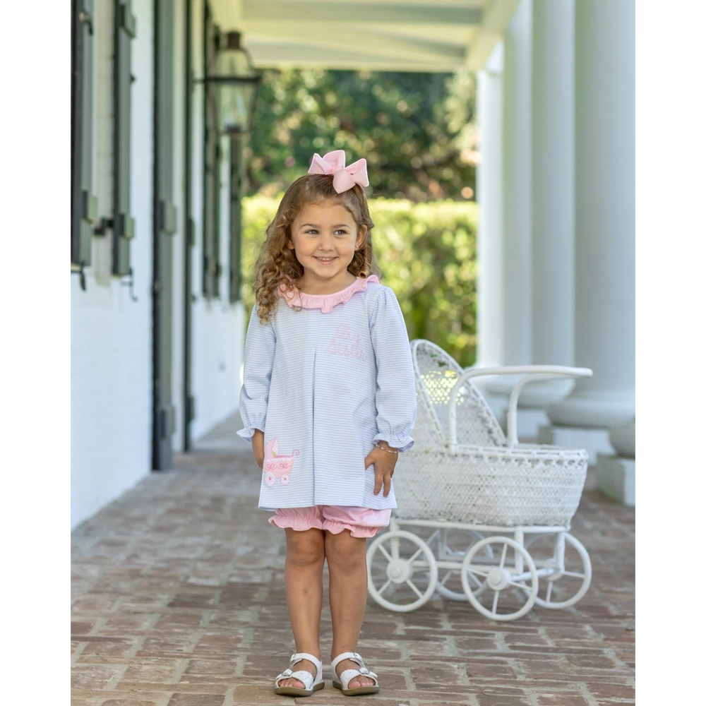 That Store Big Sister blue stripe bloomer set with pink ruffles worn by a young girl on a porch.
