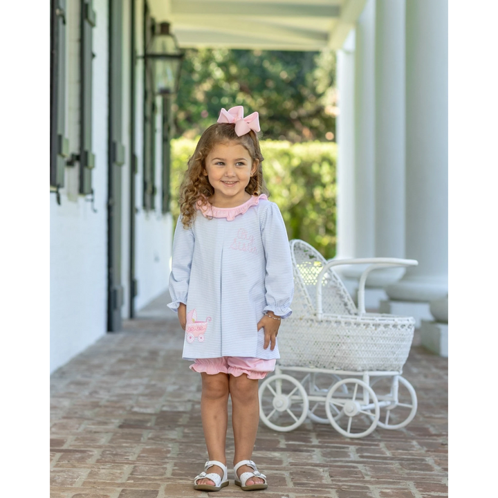 That Store Big Sister blue stripe bloomer set with pink ruffles worn by a young girl on a porch.