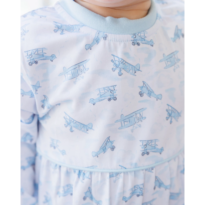 That Store blue boys romper featuring a playful airplane print on soft cotton blend fabric with a round neckline.