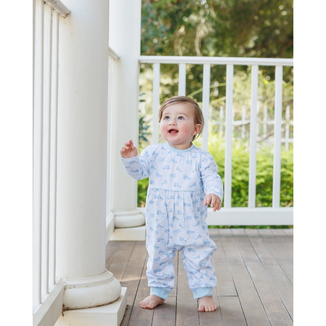 Toddler wearing a That Store blue airplane print cotton romper standing on a porch