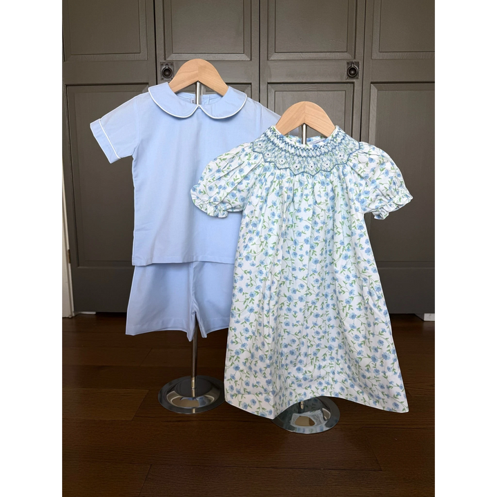 That Store blue boy short set with peter pan collar paired with a matching floral smocked dress on display