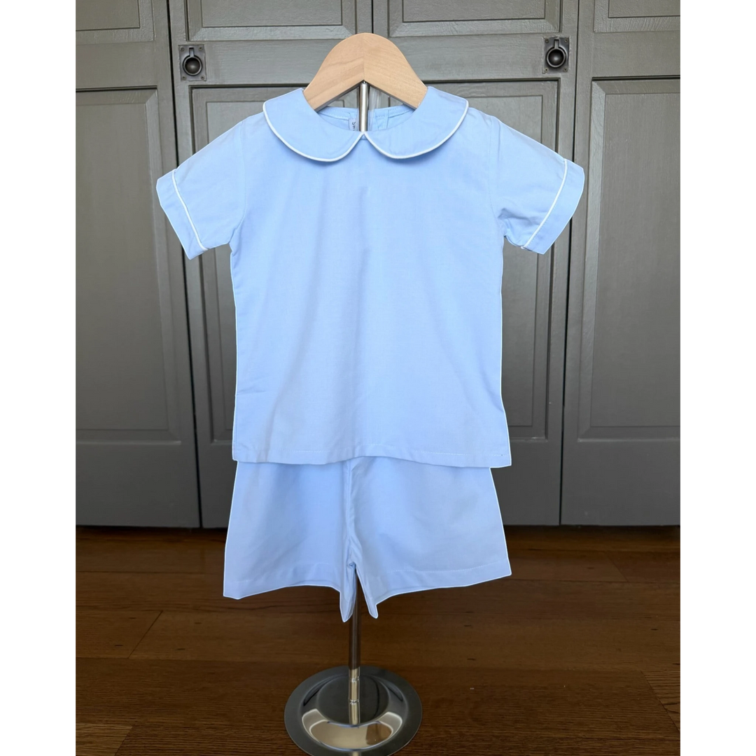 That Store classic light blue boy short set with a peter pan collar and white piping detail on a wooden hanger.