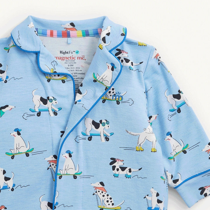 That Store baby coverall in light blue with a playful dog on skateboard print and contrast navy piping details