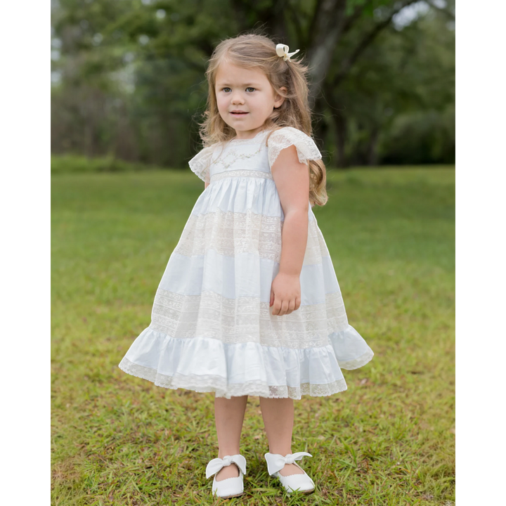 That Store Mary Frances ecru and blue cotton heirloom dress with intricate lace and floral embroidery on a young girl
