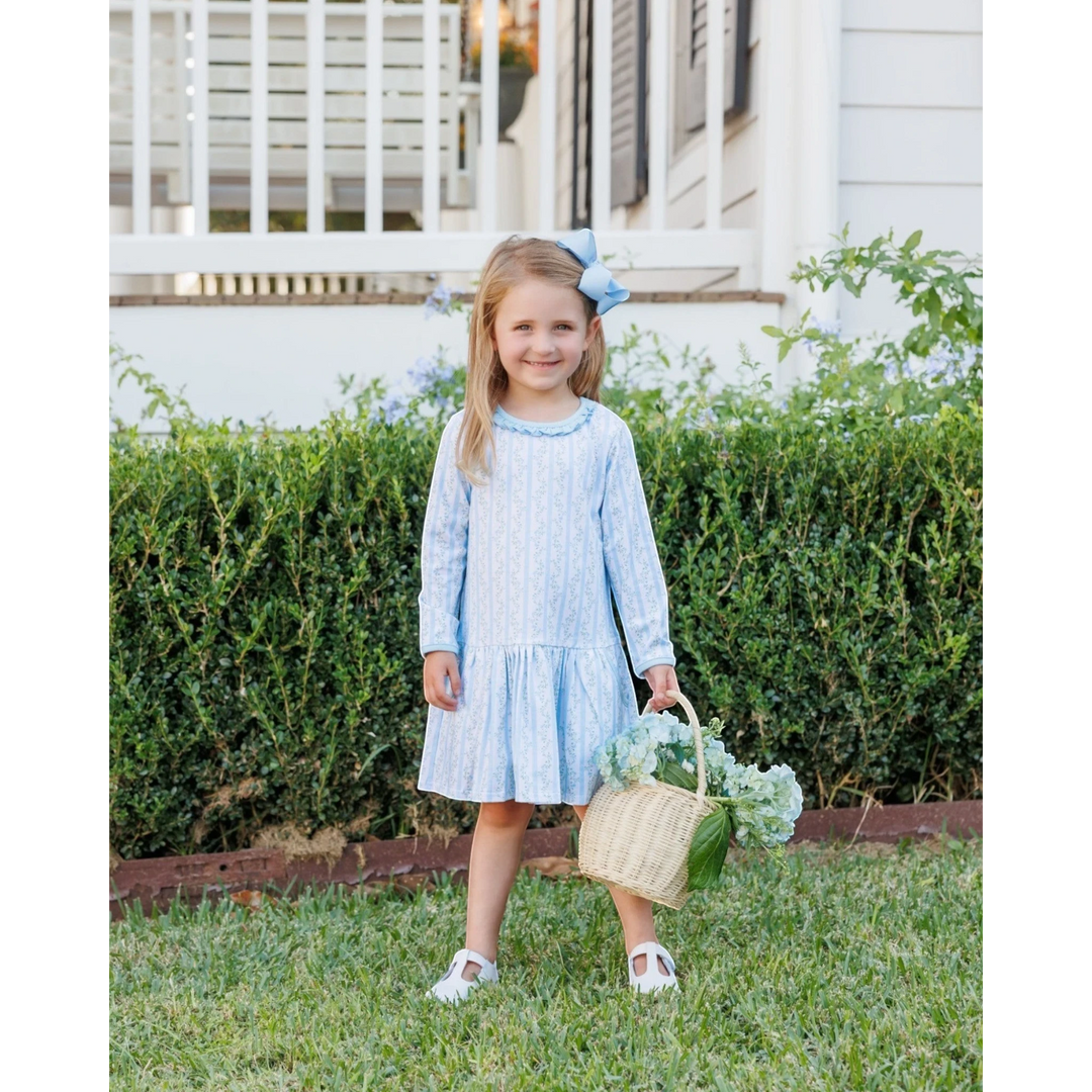 That Store Vineyard Blooms blue floral long-sleeve drop waist dress worn by a girl with a matching blue hair bow