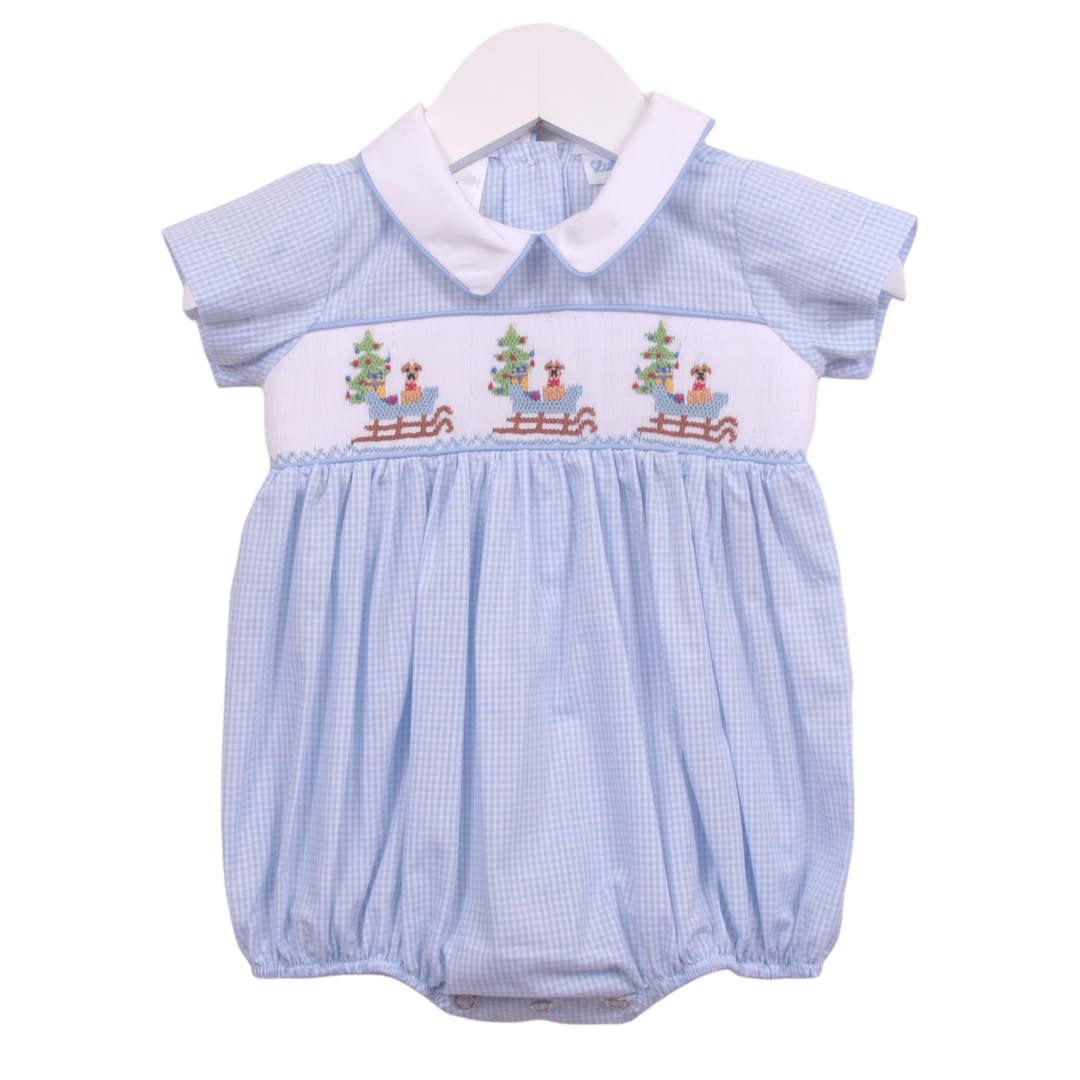 That Store boys blue gingham bubble featuring smocked puppy in a sleigh design with a white peter pan collar